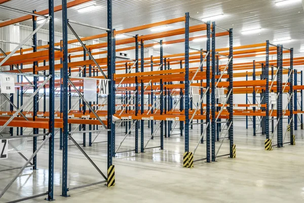 Orange warehouse shelves in grey interior. Orange storage warehouse.