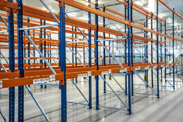 Orange warehouse shelves in grey interior. Orange storage warehouse.