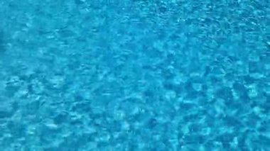 Kamuoyu yoklamalarında güneş yansımalarıyla birlikte berrak mavi su dokusu. Yüksek kalite 4k görüntü