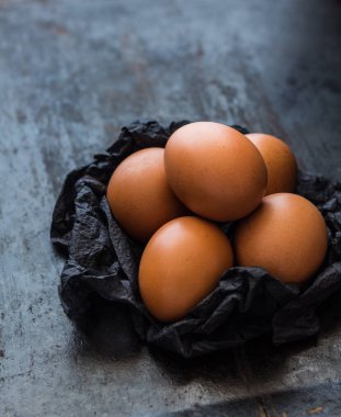 Koyu arka plan üzerinde siyah peçeteye kahverengi yumurta