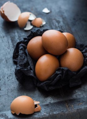Koyu arka plan üzerinde siyah peçeteye kahverengi yumurta