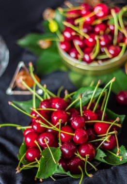 Olgun kırmızı kiraz bir metal bir avuç üzerinde siyah bir backgro olabilir