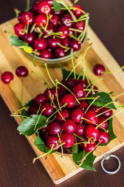 Olgun kırmızı kiraz bir metal bir avuç üzerinde kahverengi bir backgro olabilir