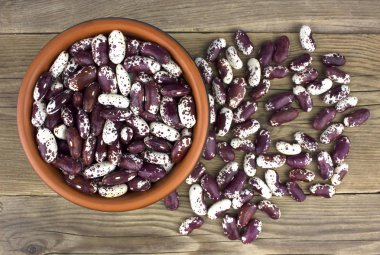 Ahşap masa üzerinde seramik kase kuru fasulye. Top vie