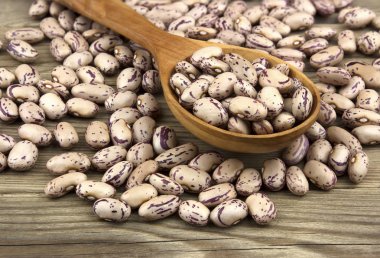 Beyaz ahşap zemin üzerinde bir tahta kaşık kuru fasulye