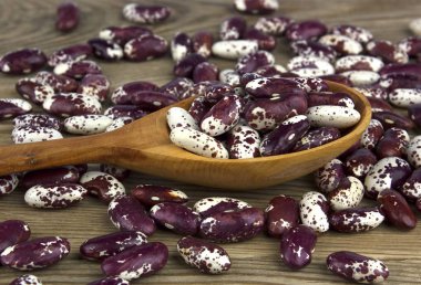 Beyaz ahşap zemin üzerinde bir tahta kaşık kuru fasulye