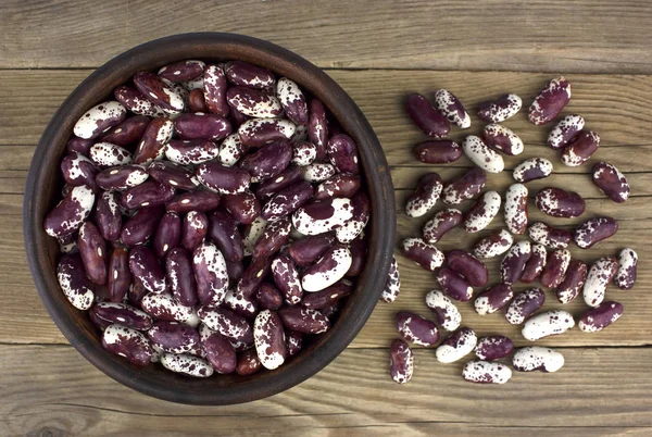 Ahşap masa üzerinde seramik kase kuru fasulye. Top vie