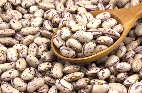 Beyaz ahşap zemin üzerinde bir tahta kaşık kuru fasulye