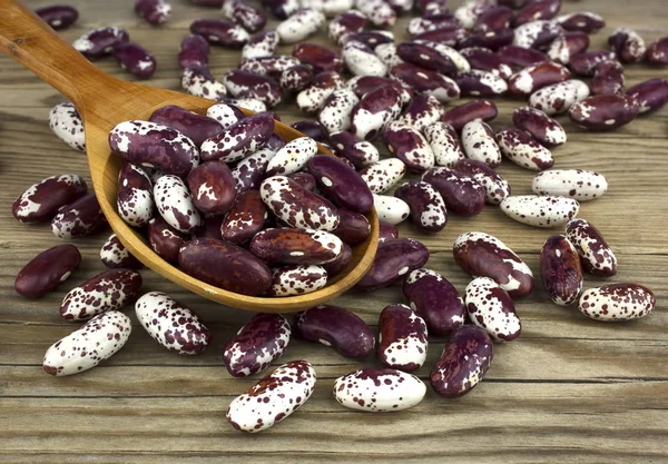 Beyaz ahşap zemin üzerinde bir tahta kaşık kuru fasulye