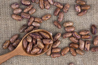 Tahta kaşık jüt üzerinde yalan fasulye tohumları tuval, sağlıklı gıda ve beslenme