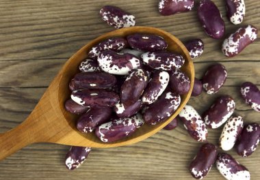 Beyaz ahşap zemin üzerinde bir tahta kaşık kuru fasulye