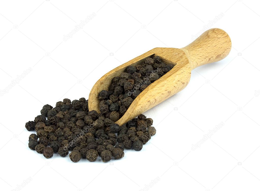 Food ingredients: heap of black pepper in a wooden scoop, on white background