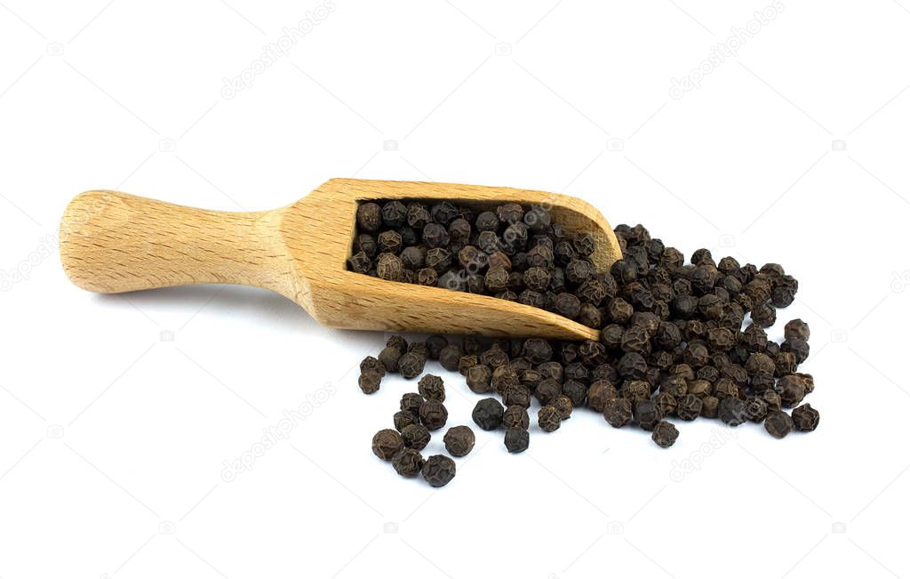 Food ingredients: heap of black pepper in a wooden scoop, on white background
