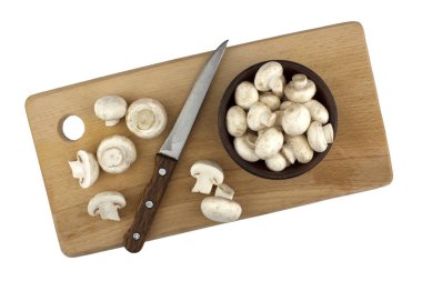 Beyaz bir arka plan üzerinde izole bir ahşap kesme tahtası üzerinde champignon mantar. Sonbaharda hasat. Gıda vejetaryen. Sebze. 