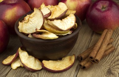 Eski ahşap masa taze elma ve tarçın ile kurutulmuş elma ile kase.