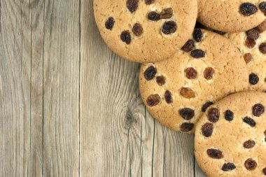 Koyu ahşap zemin üzerine üzümlü yulaf ezmeli kurabiye 