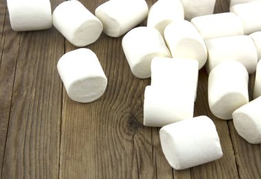Eski ahşap masa üzerinde Mini kabarık beyaz marshmallow 