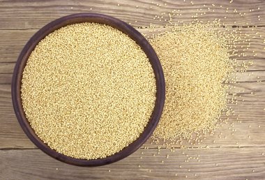 Ahşap arka plan üzerinde izole seramik kase Amaranth tohumları. 