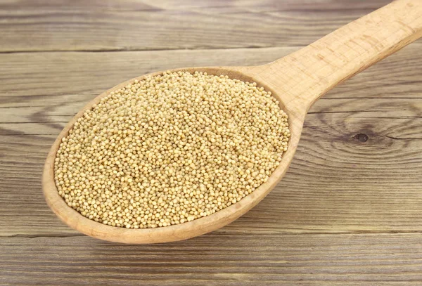 Ahşap arka plan üzerinde ahşap kaşık Amaranth tohumları. 