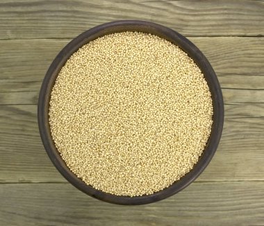 Ahşap arka plan üzerinde izole seramik kase Amaranth tohumları. 