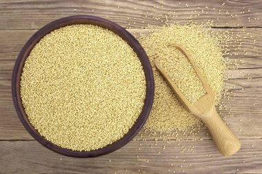 Ahşap sırt üzerinde izole kepçe ile seramik kase Amaranth tohumları