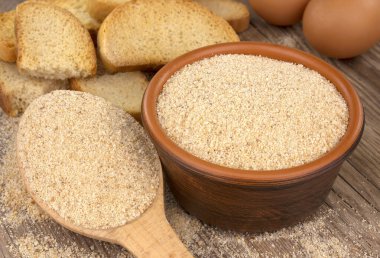 Tahta masanın üzerinde ekmek kırıntıları olan bir kase. Doğal besin maddesi.