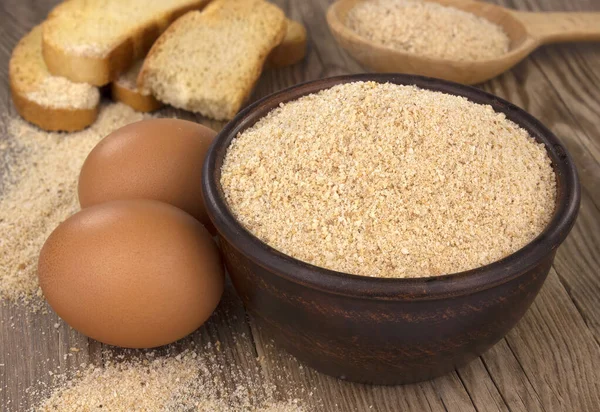 Tahta masada ekmek kırıntıları olan bir kase. Doğal besin maddesi.