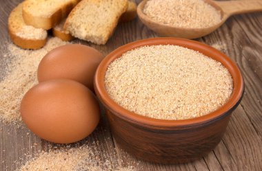 Tahta masada ekmek kırıntıları olan bir kase. Doğal besin maddesi.