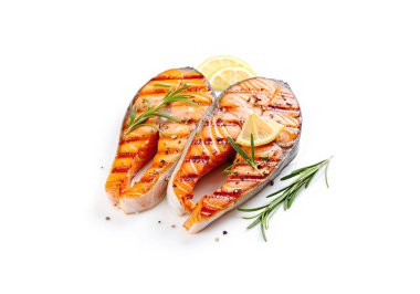 Izgara somon bifteği, biberiye, limon ve biberli beyaz arka plan.