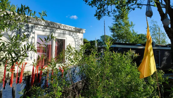 Amsterdam Houseboats nad brzegiem rzeki Amstel z kolorowymi flagami świąt i słońcem — Zdjęcie stockowe