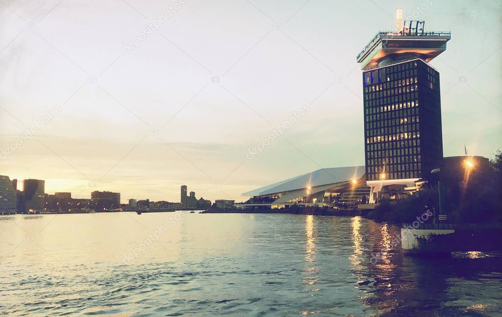 sunset over the skyline of the old city of amsterdam with ADAM tower at the river IJ