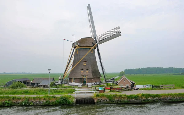 Molinos de viento holandeses en Kinderdijk, un famoso pueblo en los Países Bajos donde se pueden visitar los antiguos molinos de viento tradicionales —  Fotos de Stock