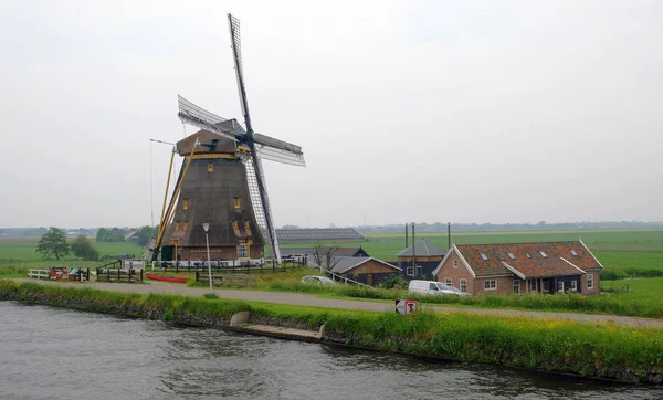 Molinos de viento holandeses en Kinderdijk, un famoso pueblo en los Países Bajos donde se pueden visitar los antiguos molinos de viento tradicionales —  Fotos de Stock