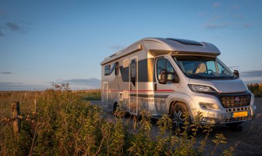 Motosikletli karavan gün batımı ve muhteşem manzarası olan tepede güzel bir paradisiacal yere park ediyor.