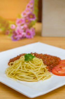 Spagetti Bolognese yemek fesleğen yaprakları ve domates ile