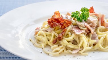 Pastırmalı spagetti ve beyaz tabakta peynir.