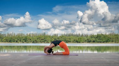 Asyalı kadın pratik yoga poz, güzel göl - manzaralı açık havada egzersiz dinlenmek doğa