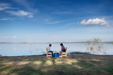 İki mutlu kardeşler yakın göl doğada satranç bir oyun oynuyor