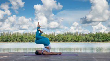 Asyalı kadın pratik yoga poz, güzel göl - manzaralı açık havada egzersiz dinlenmek doğa