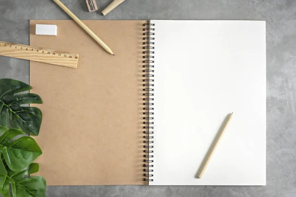 Cuaderno de bocetos en blanco y hojas verdes — Foto de Stock