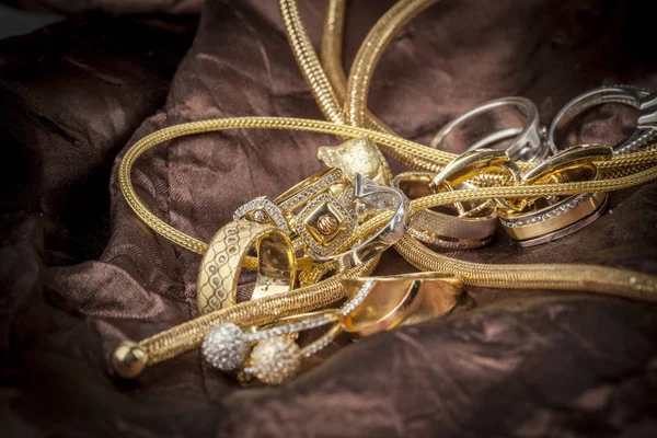 金の宝石類は 茶色の背景にクローズ アップ — ストック写真