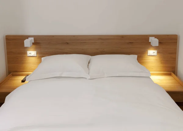 wooden bed in room with smal night lights