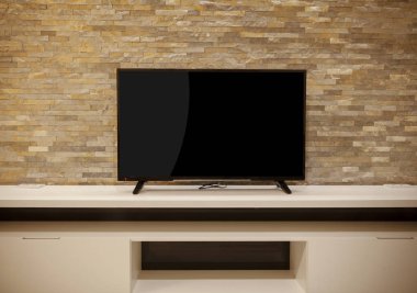 beyaz bir raf, taş duvar büyük düz ekran Tv