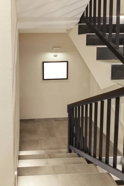 stairs in the hallway of the building with a picture on the wall