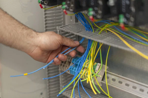コントロールパネルの電線を接続する電気技師 — ストック写真