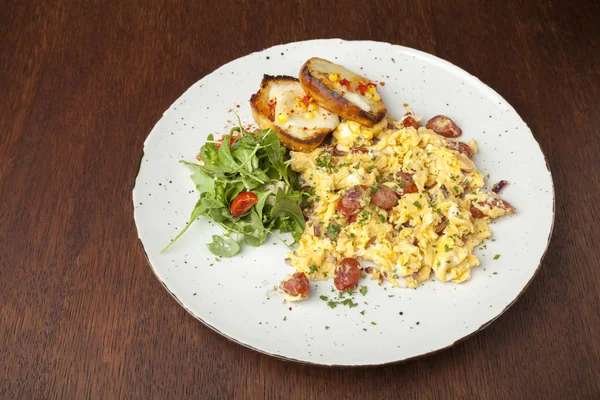 Oeufs brouillés avec saucisse et roquette — Photo