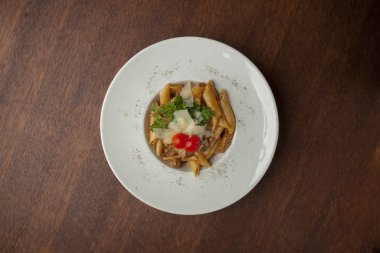 ahşap masada doğranmış beefsteak ve domates ile makarna