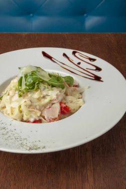 ahşap masada doğranmış beefsteak ve domates ile makarna