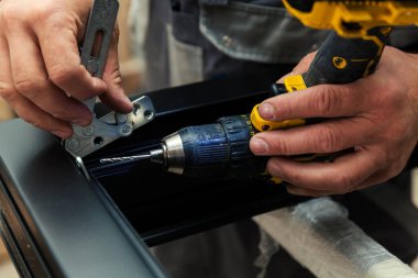 Metal parçaları ahşap pencerelere elle yerleştirip, kapatıyorlar.