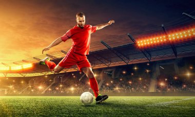 Bir oyun sırasında bir stadyumda bir top ile eylem futbolcu. Dramatik gece gökyüzü ile ışıklandırılmış gece futbol stadyumu
